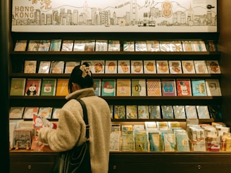A woman browses postcards in a gift shop.