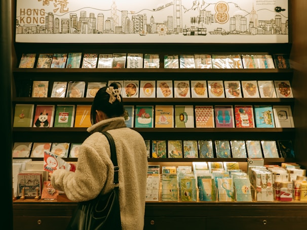 A woman browses postcards in a gift shop.