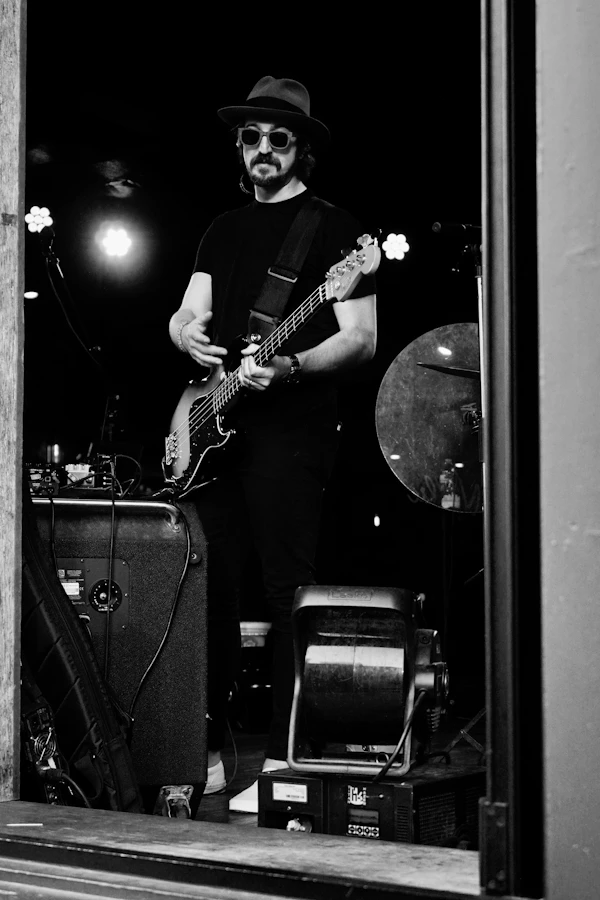 Musician playing bass guitar on a dark stage