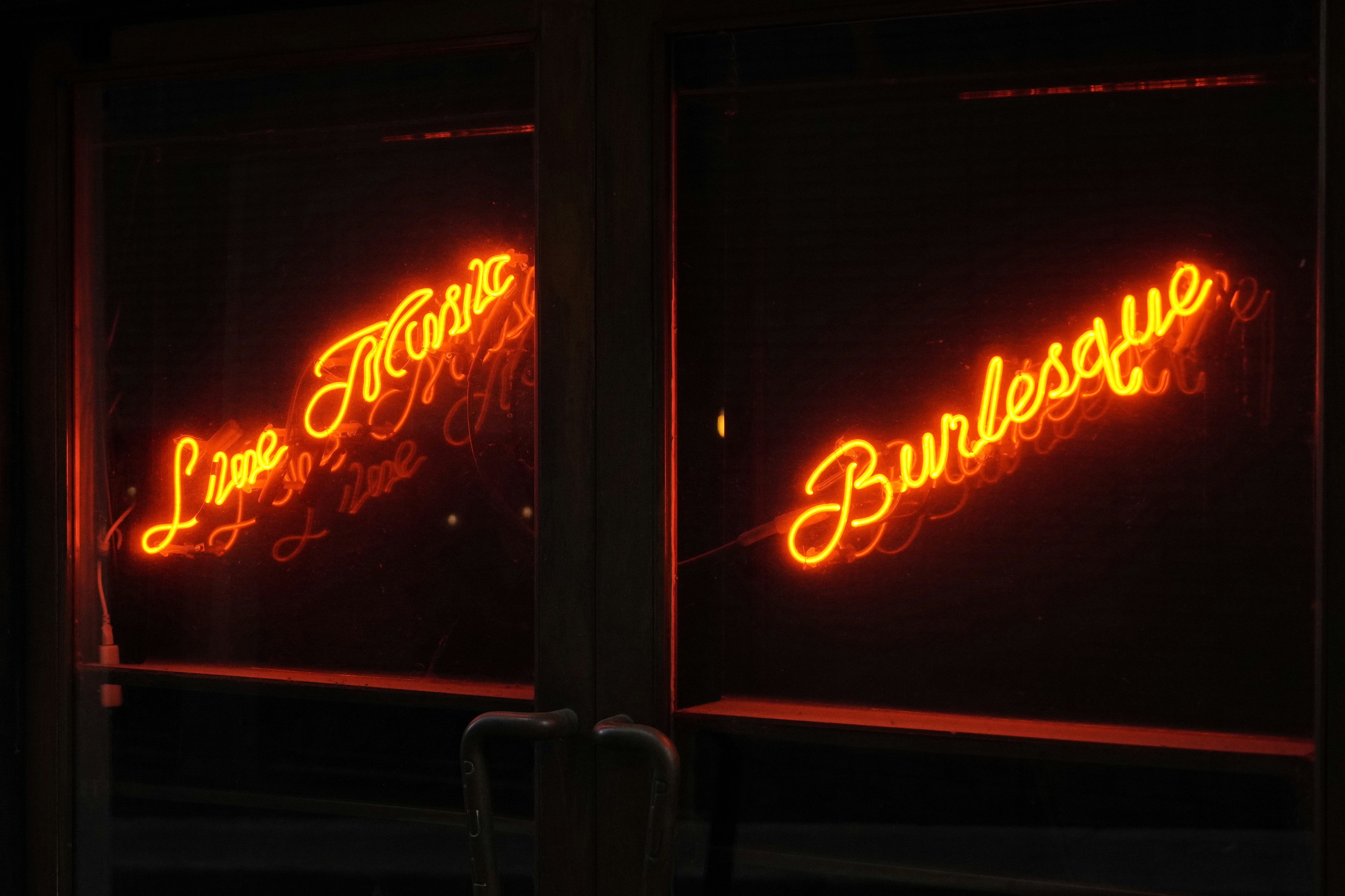Neon signs advertise "live music" and "burlesque.", 