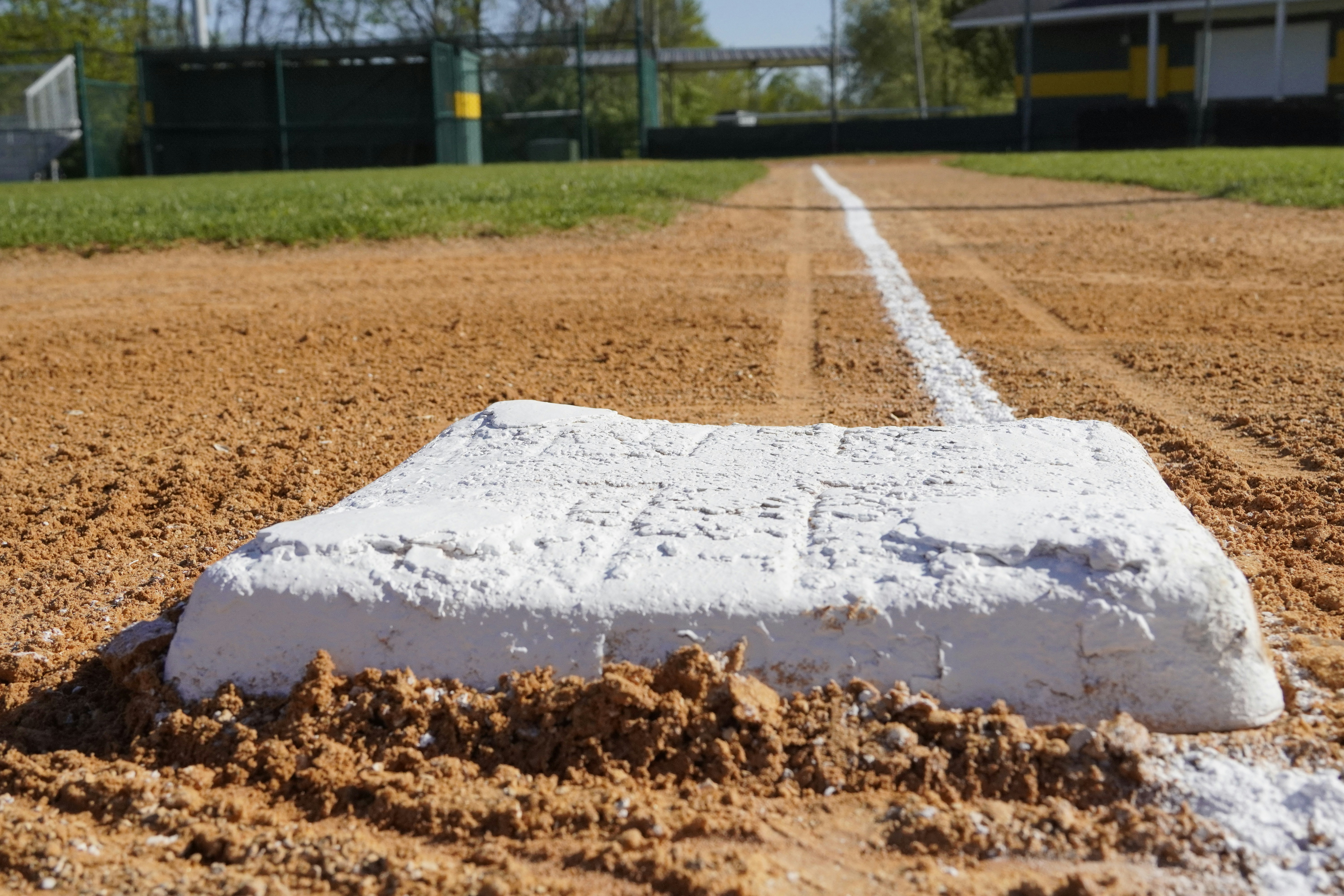 A baseball base stands out on the diamond.