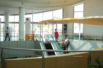 People ride escalators in a modern building.