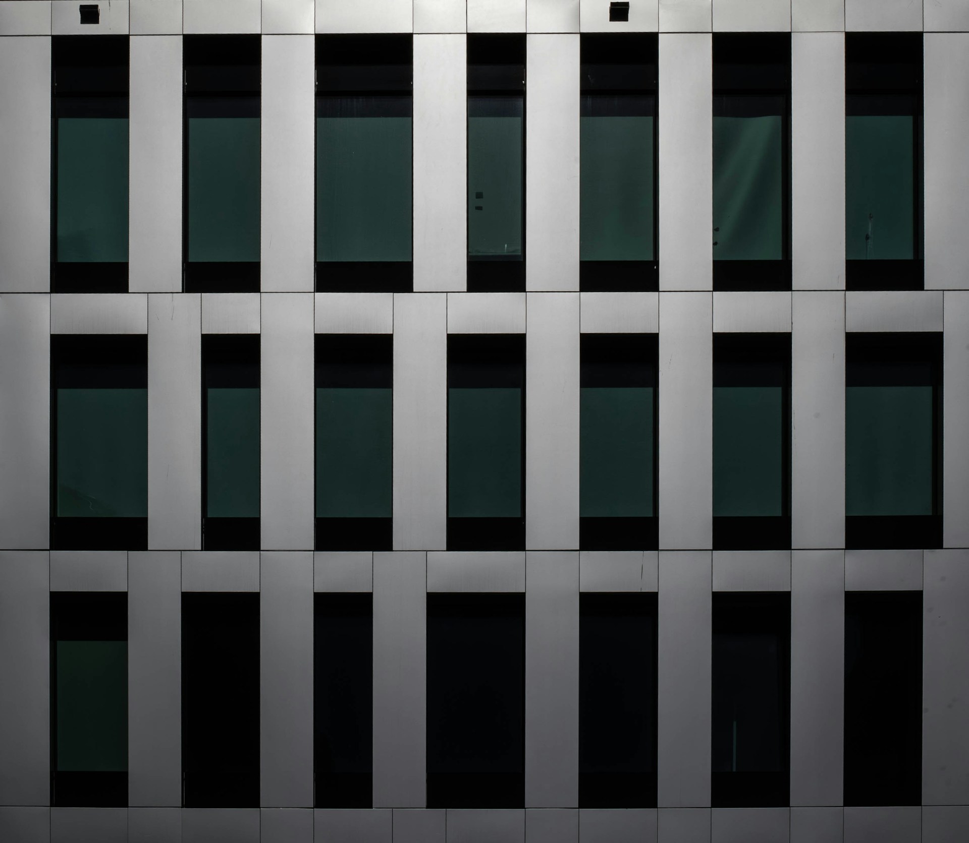 Building facade with rectangular windows and panels.