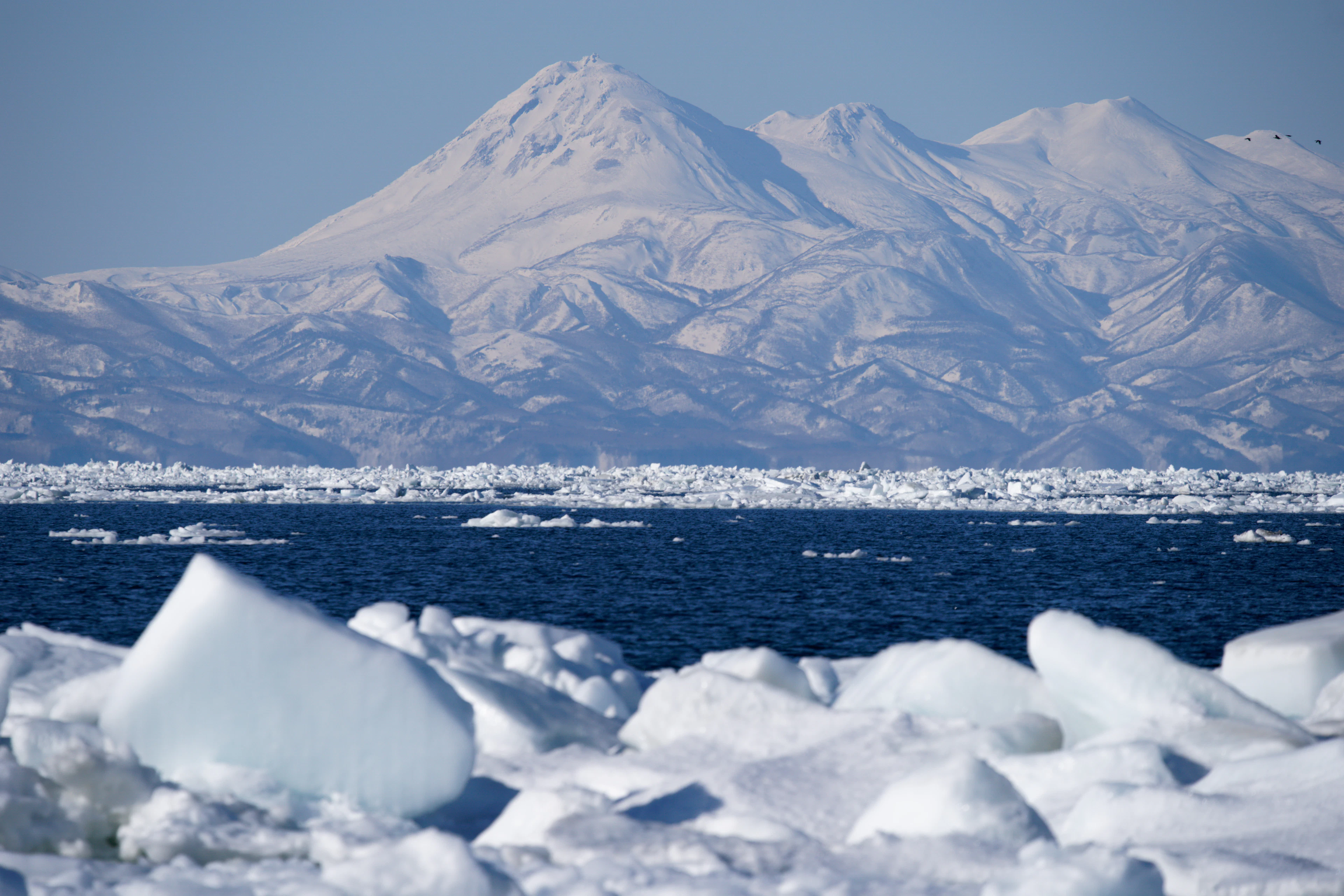 Drift ice and snow-covered mountains on a winter coast of Hokkaido