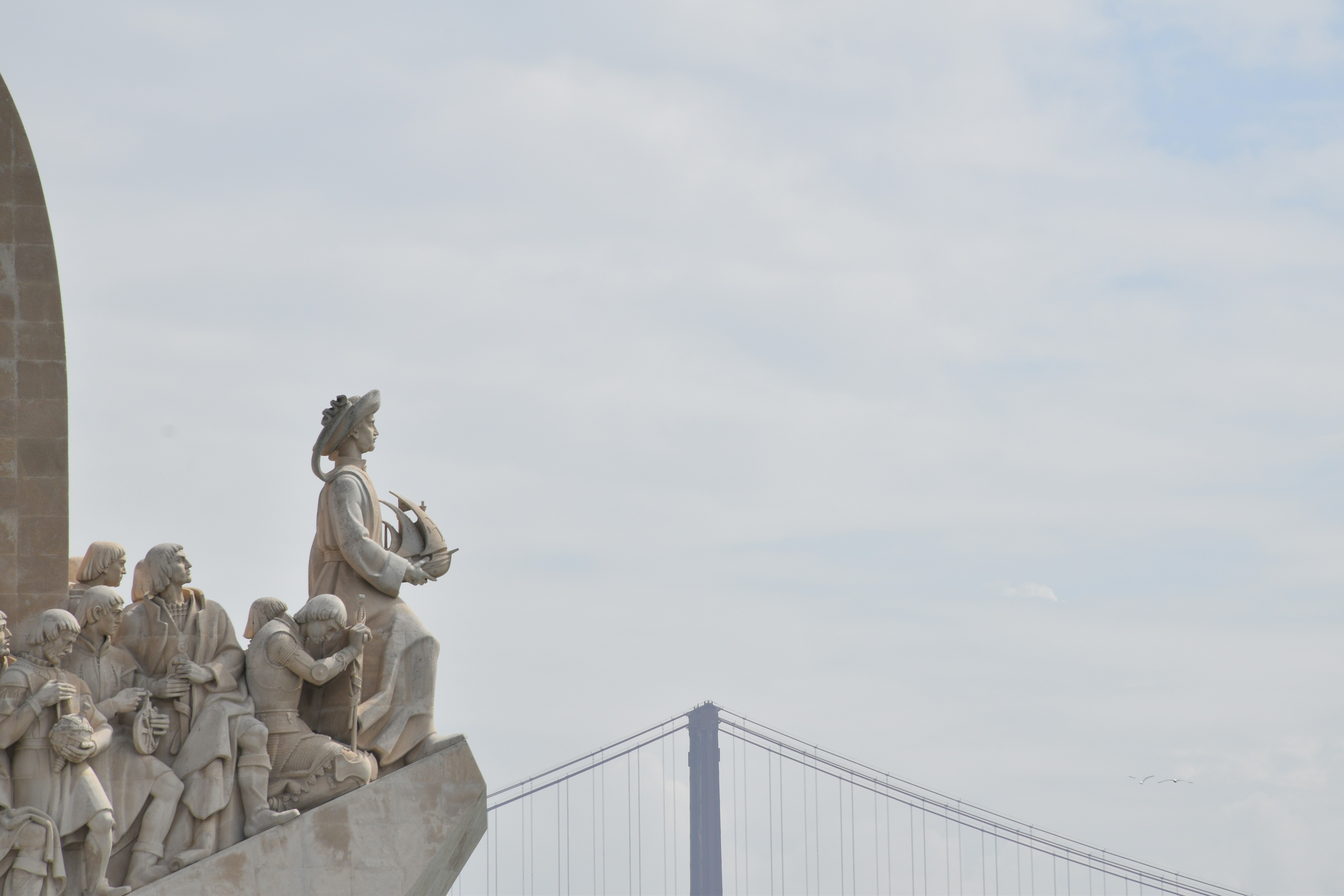 Monument to the discoveries with a bridge in the background.