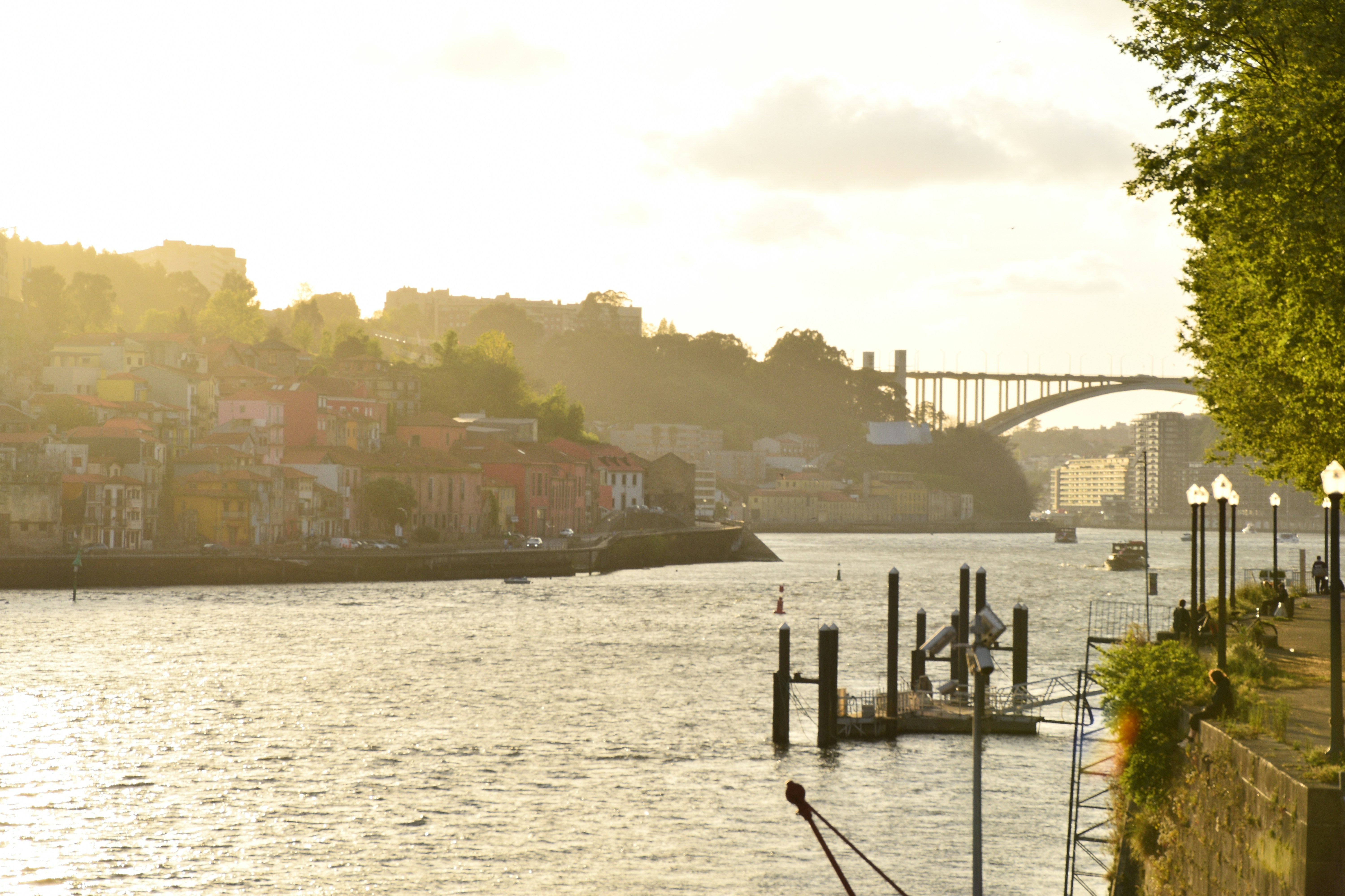 A river flows past a city at sunset.