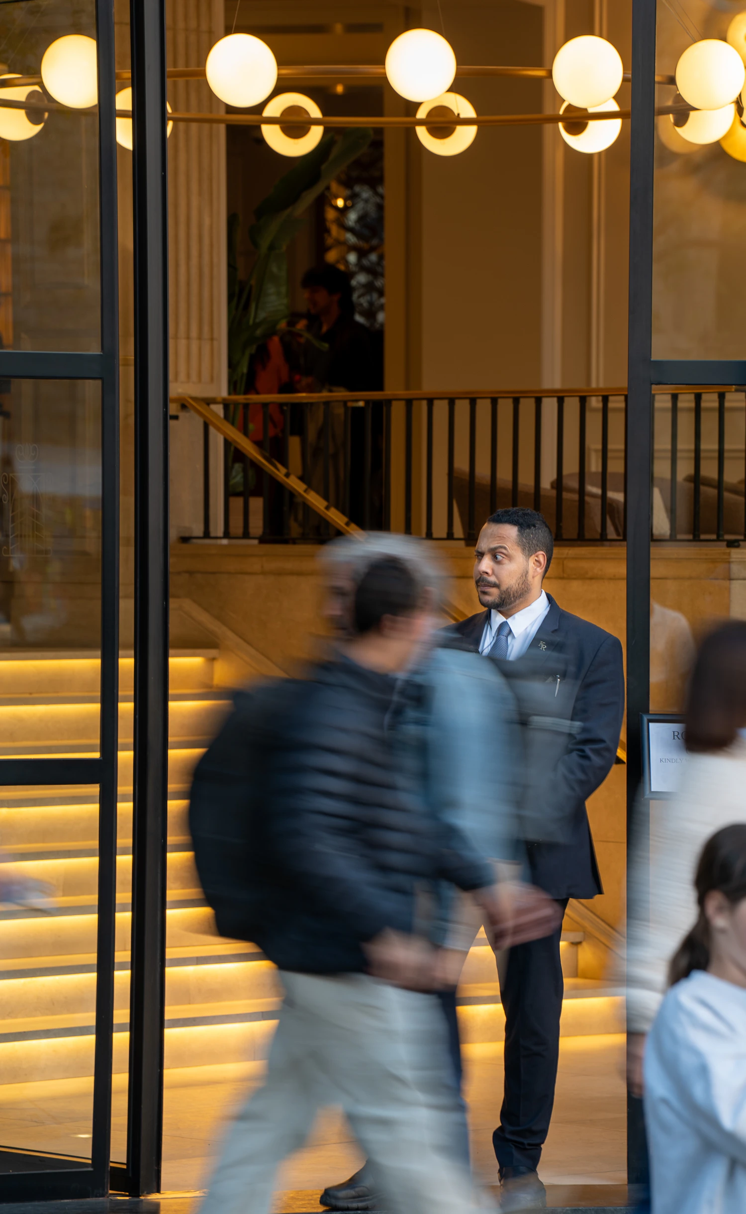 Security guard observing people entering a commercial building