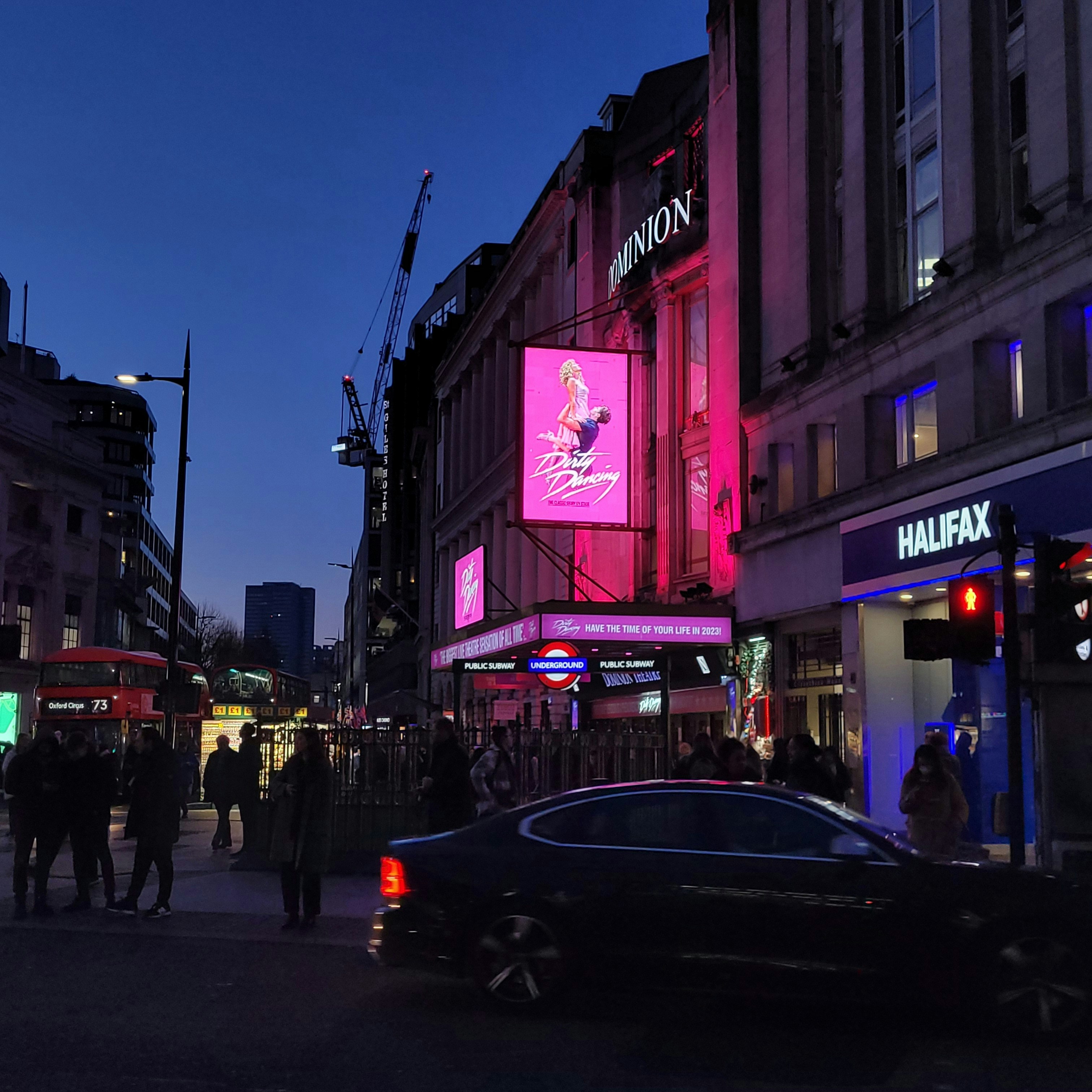 Evening street scene with lit signage.