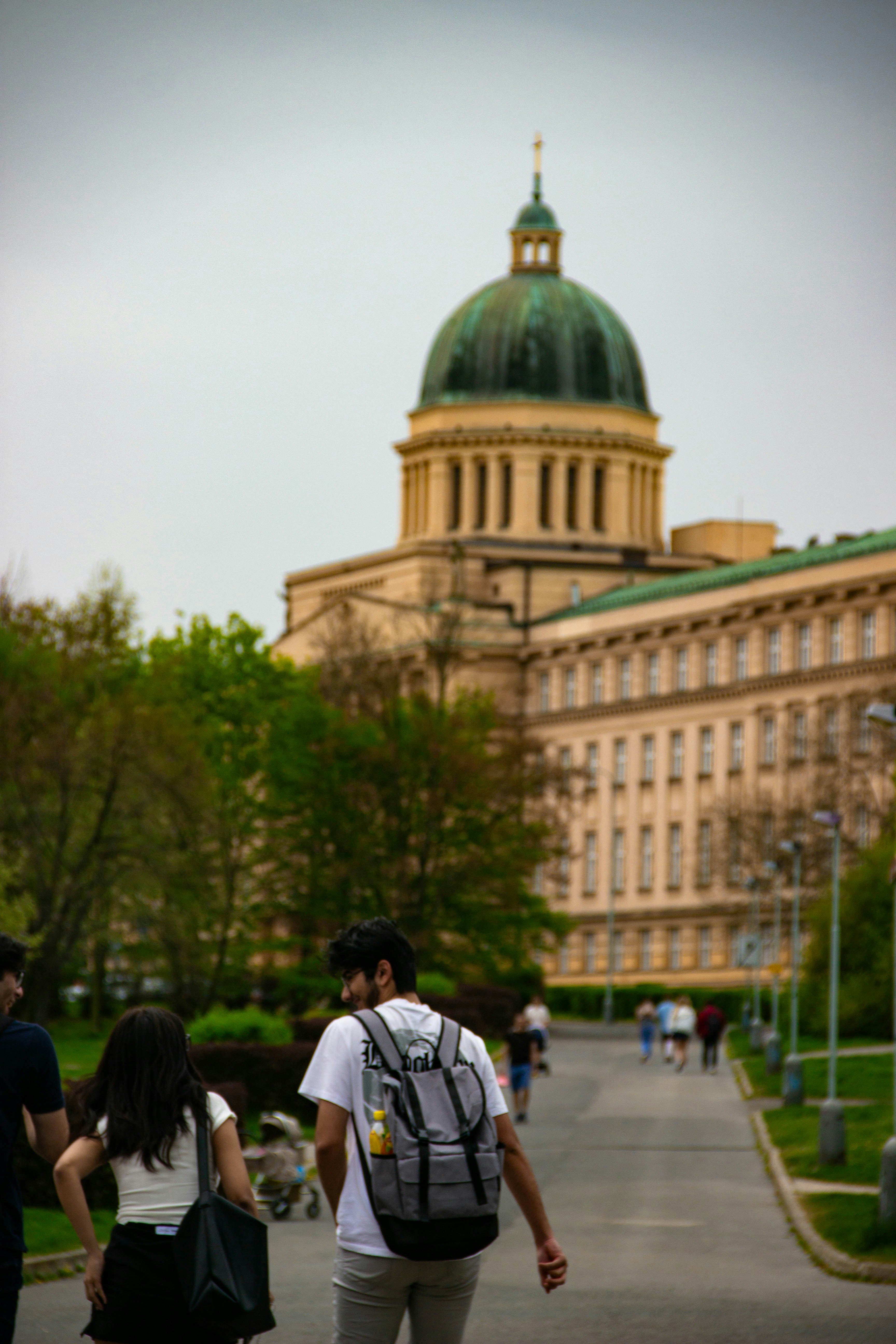 People walk past a grand building.