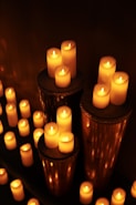 Glowing candles illuminate a dark room.