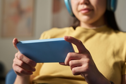 Woman holds a phone and wears headphones.