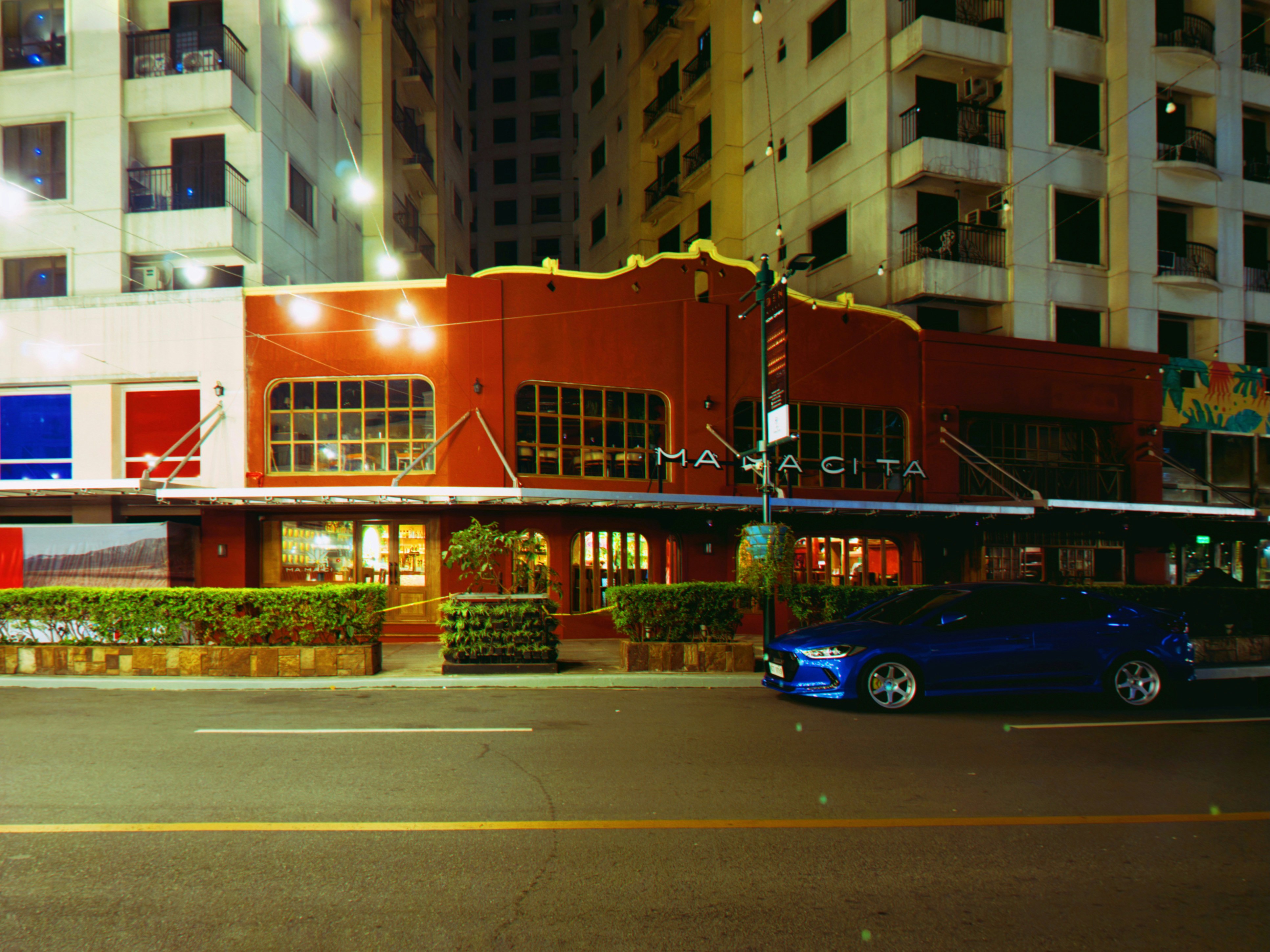 A building is illuminated at night with a car.