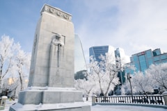 A war memorial stands in a snow-covered city.