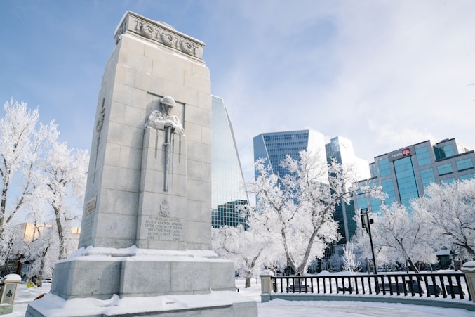 A war memorial stands in a snow-covered city.