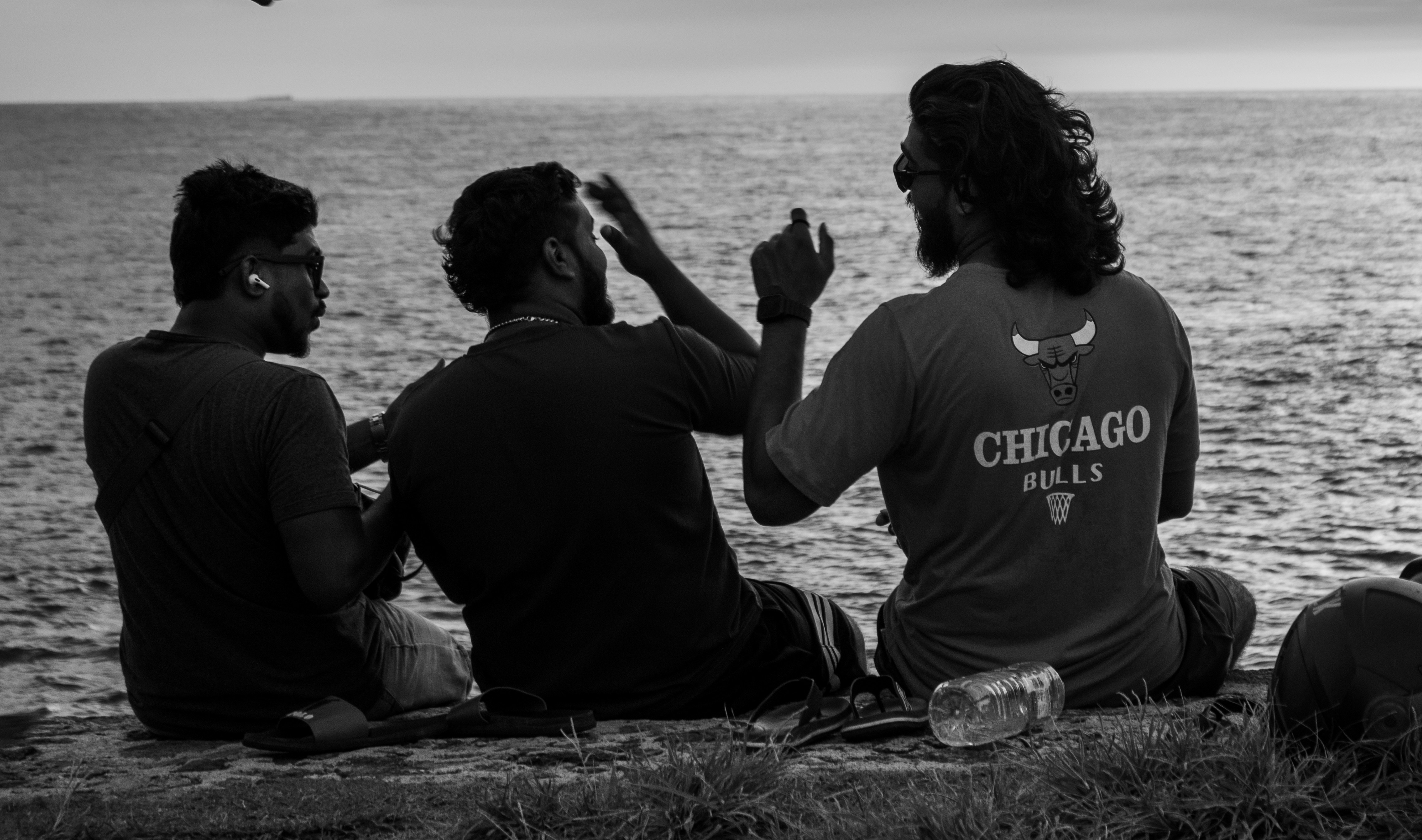 Three friends chat by the ocean.