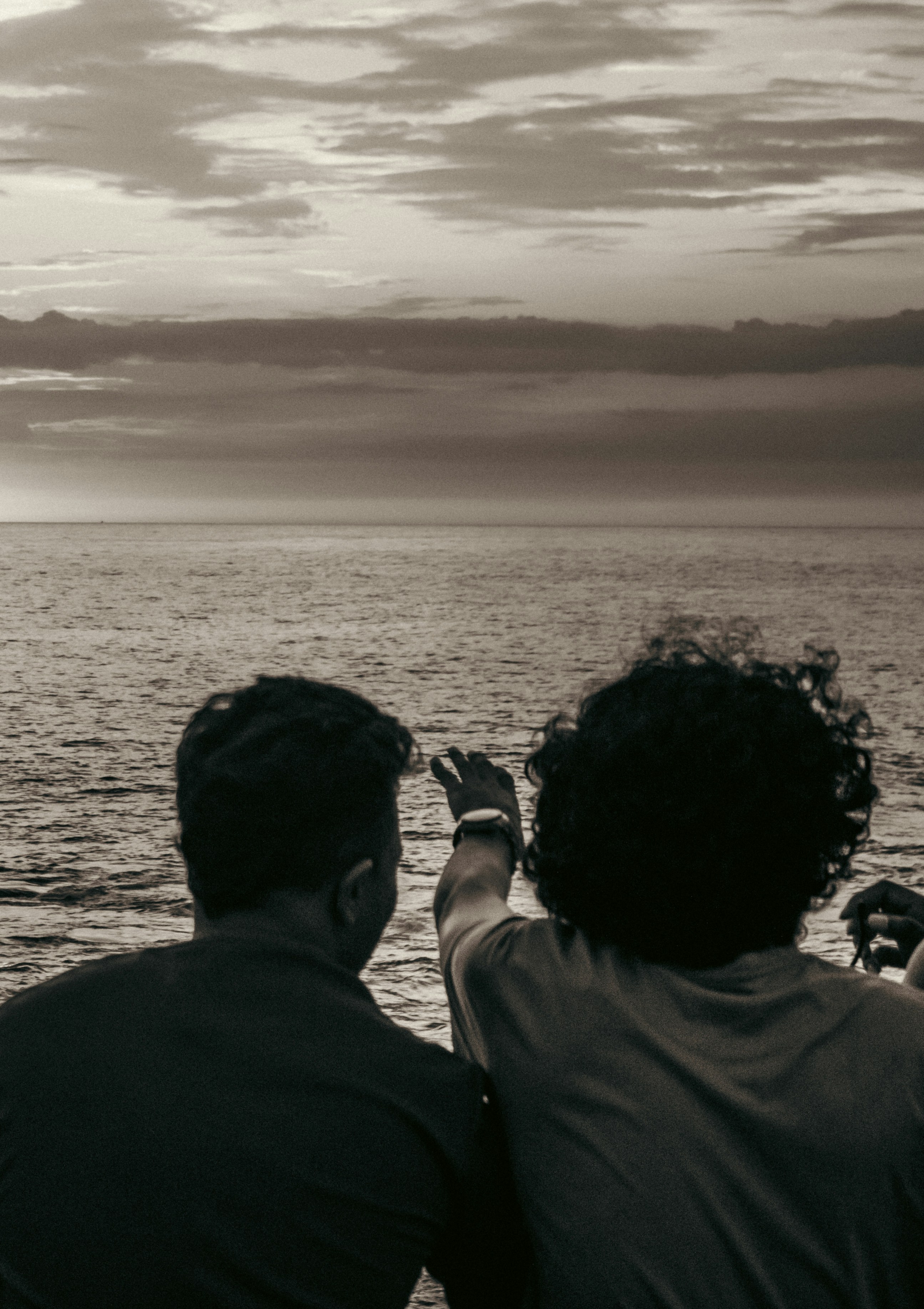 Two people talking in front of the ocean 