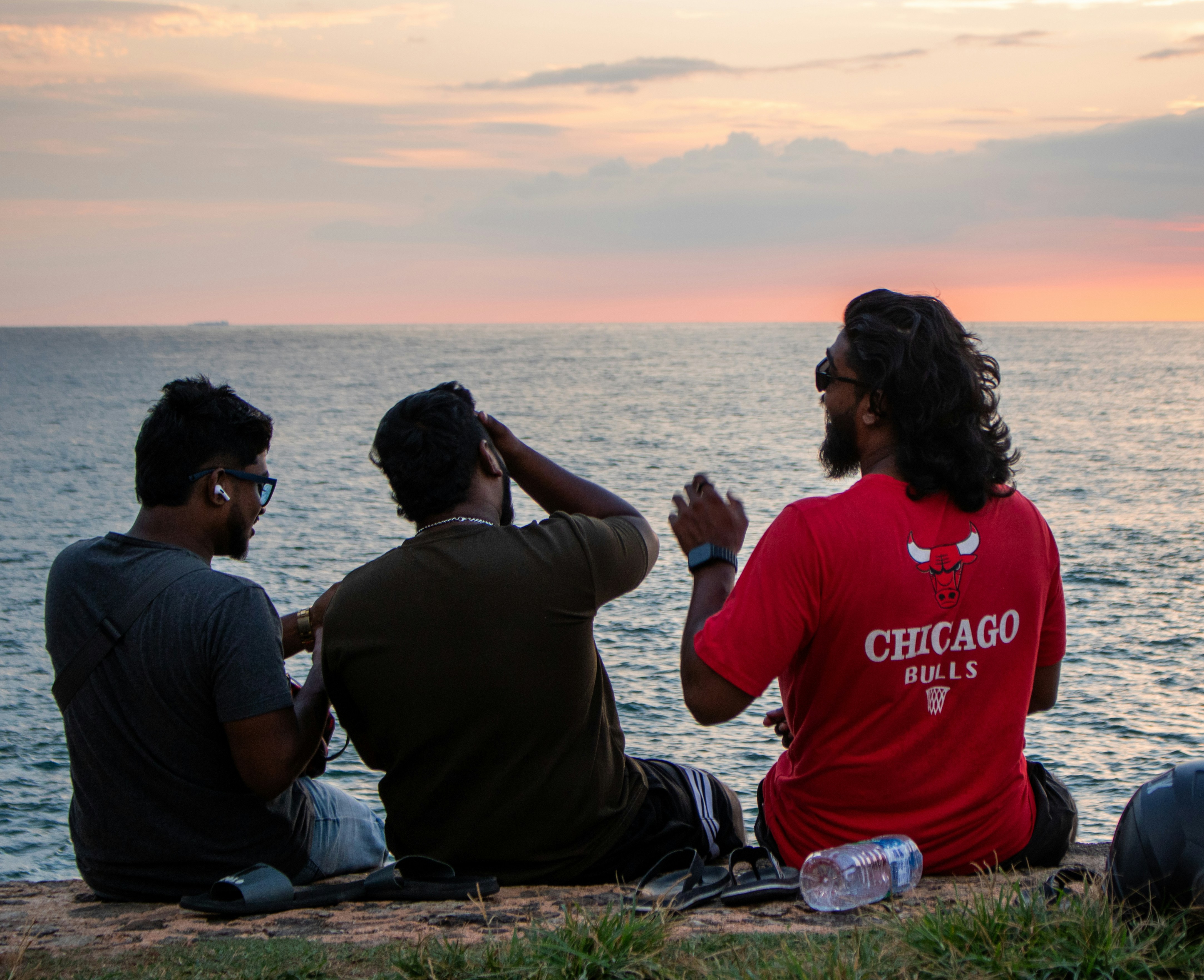 Friends enjoy the sunset view by the ocean.