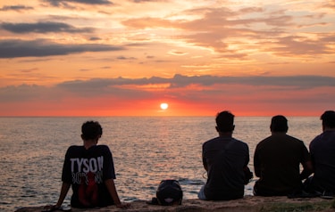 People watch the sunset over the ocean together.