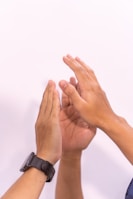 Hands are clapping in front of a white background.