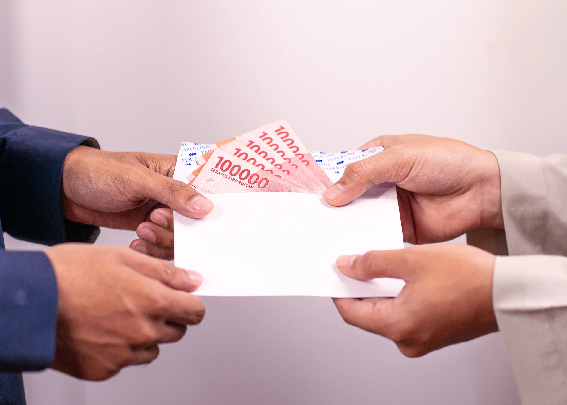 A person is giving money in an envelope.