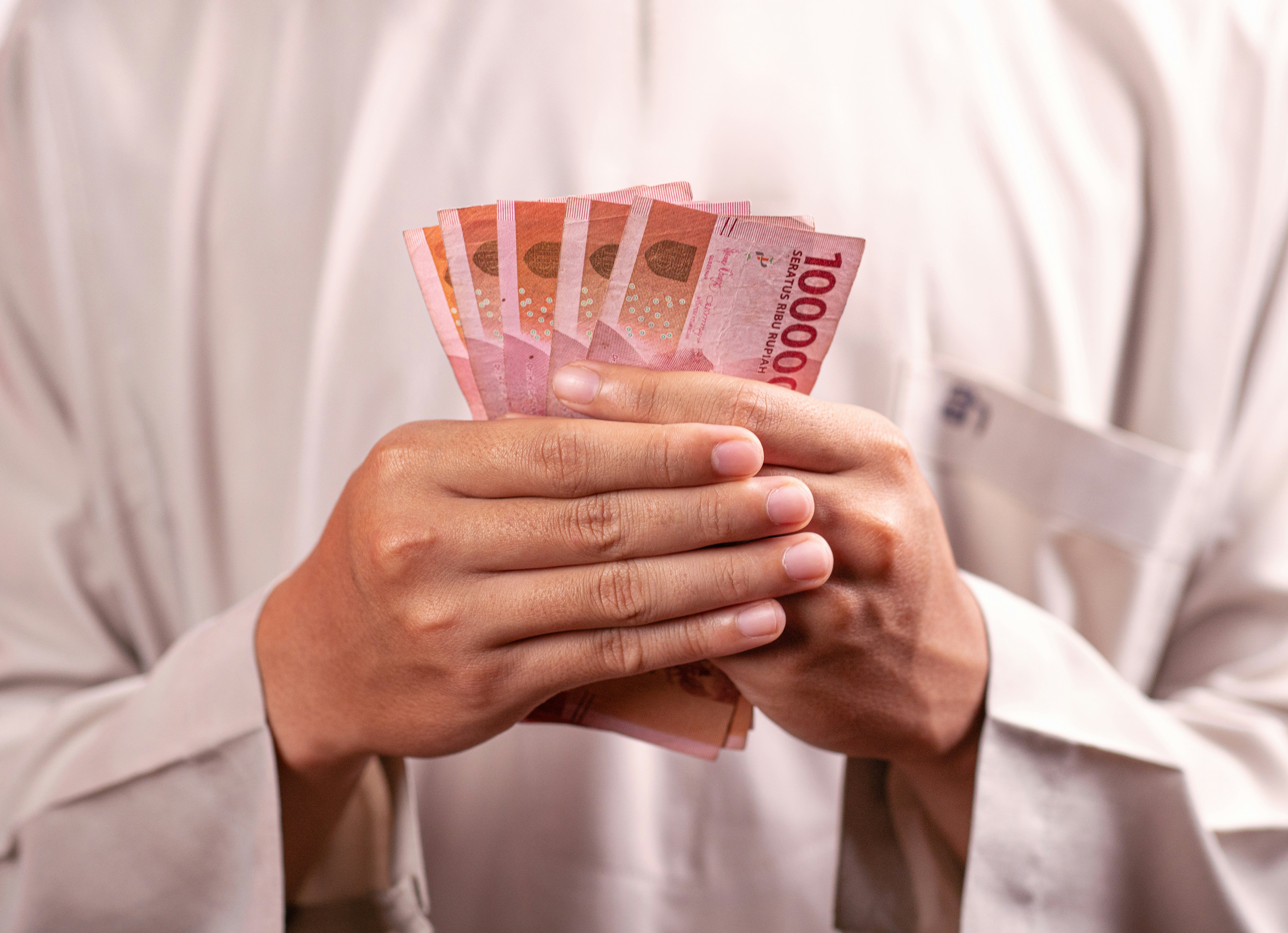 근로장려금조회 - Hands are holding a bundle of indonesian banknotes.