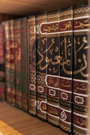A bookshelf displays several antique, arabic-script books.