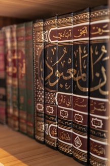 A bookshelf displays several antique, arabic-script books.