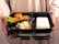 A person holds a bento box meal.