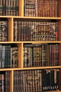 Bookshelf filled with beautifully bound, aged books.