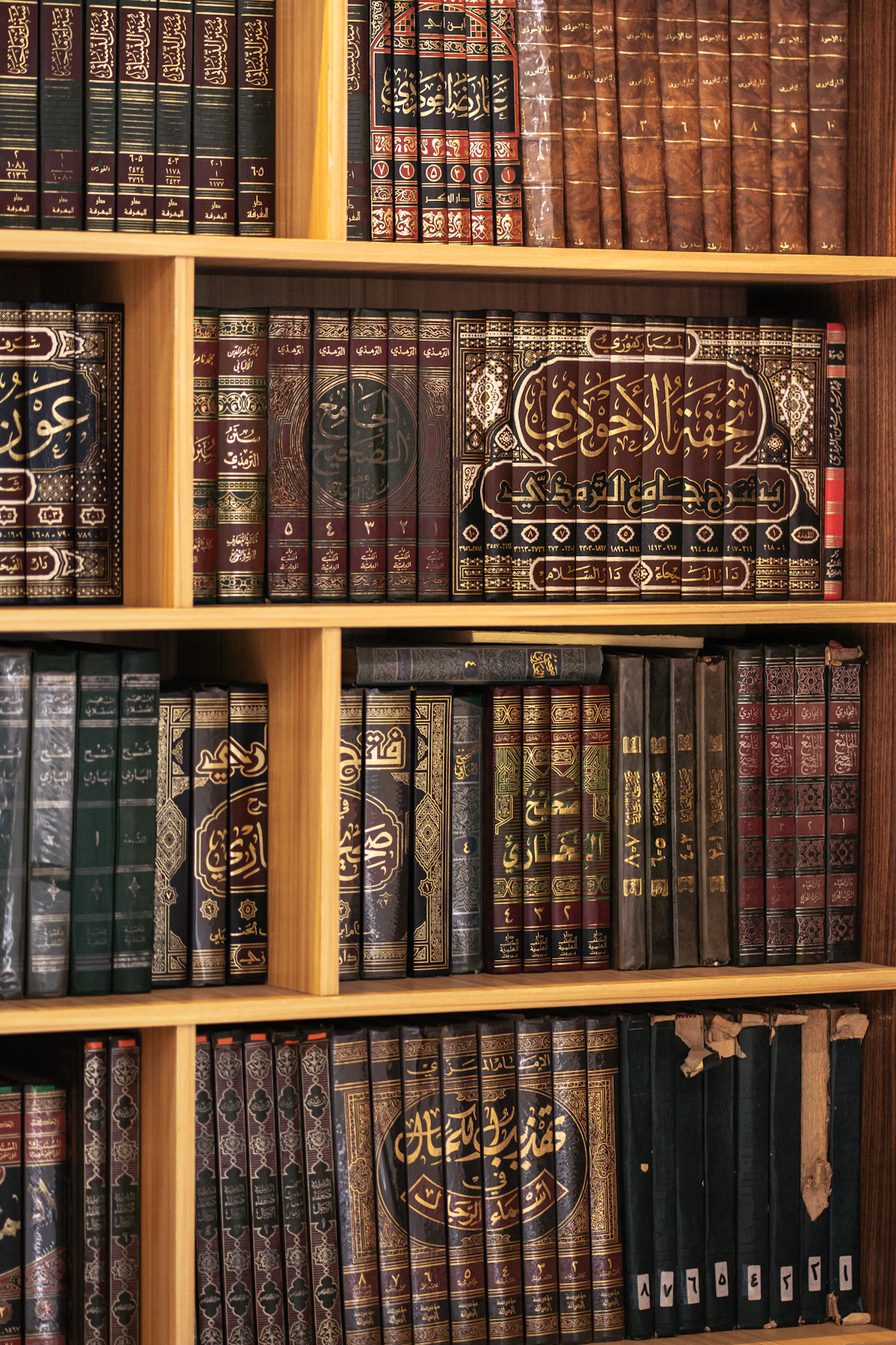 Rak buku berisi buku-buku tua berjilid indah