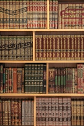 A bookshelf is filled with vintage, leather-bound books.
