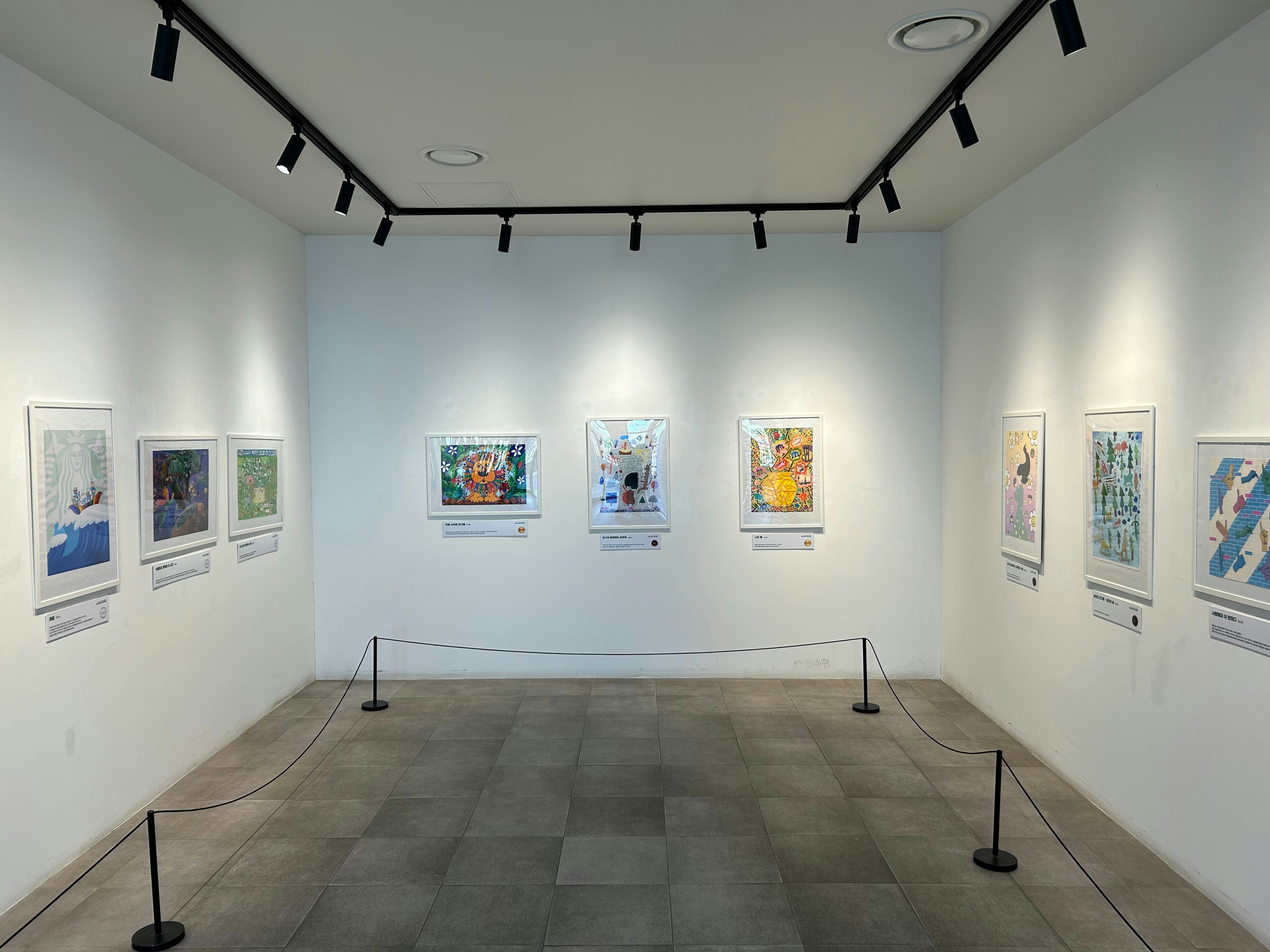 Artwork is displayed in a well-lit art gallery.
