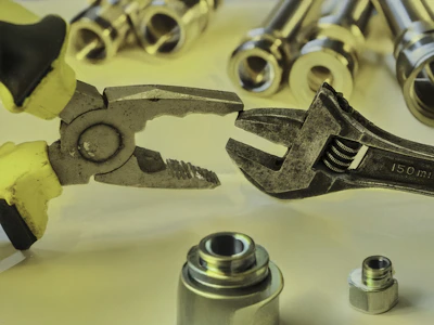 Pliers and a wrench interacting with metal parts