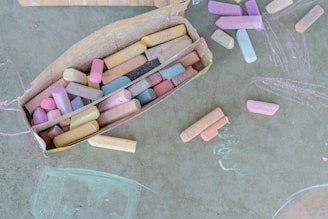 Chalk sticks are scattered on a textured surface.