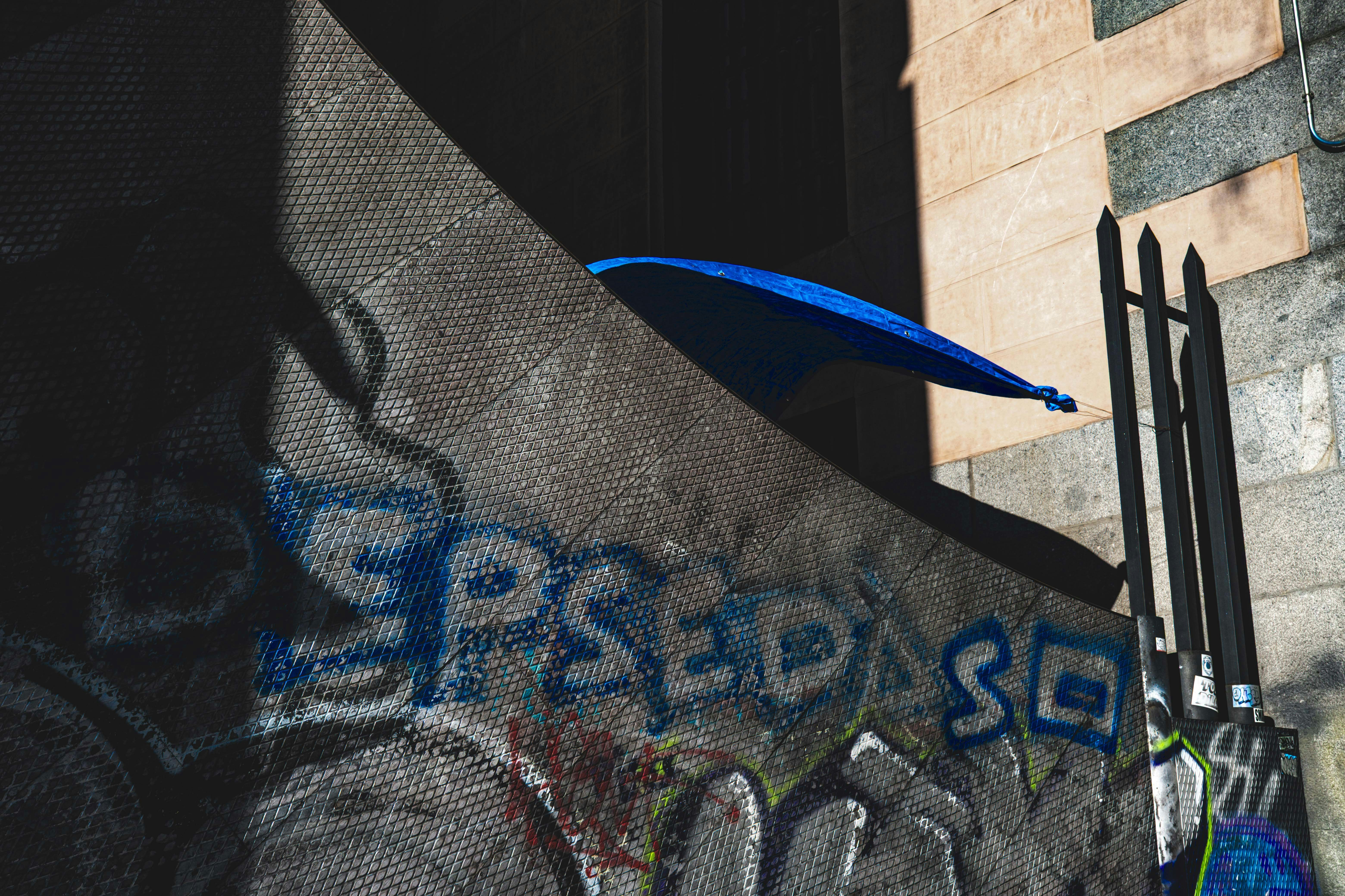 Fotomural Graffiti-covered wall with a blue umbrella