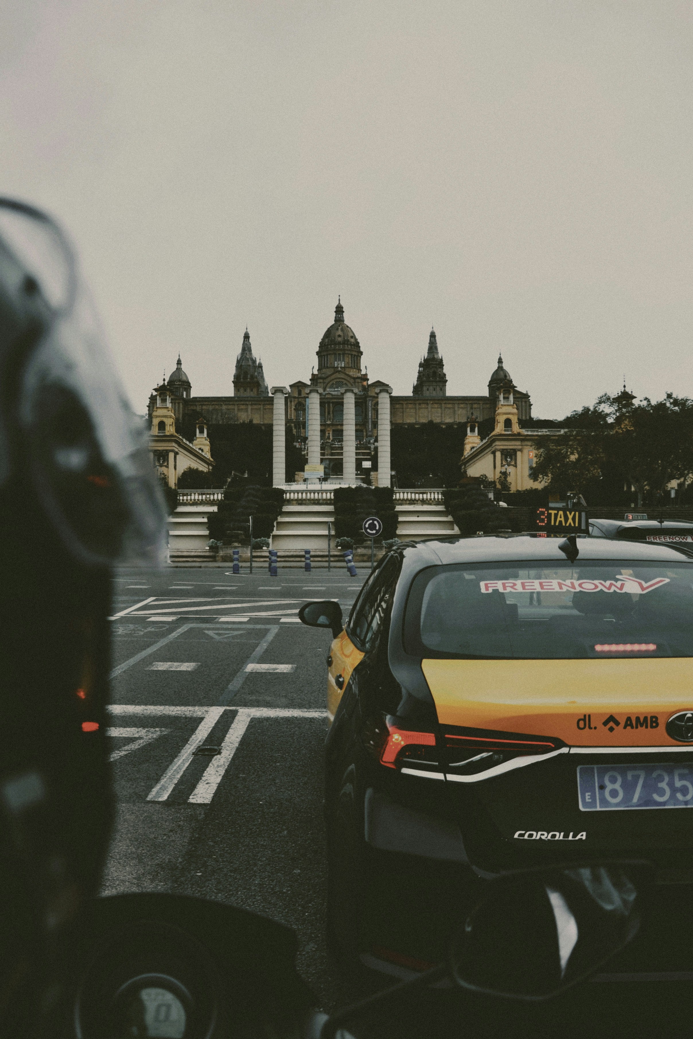 Taxi cabs are near a grand building.