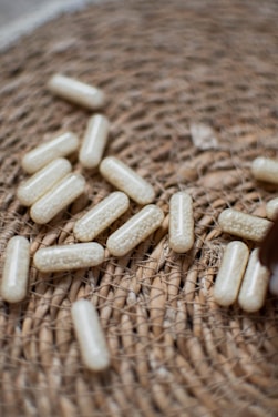 Capsules are scattered on a woven surface.
