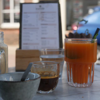 Fresh juice and coffee on an outdoor table.