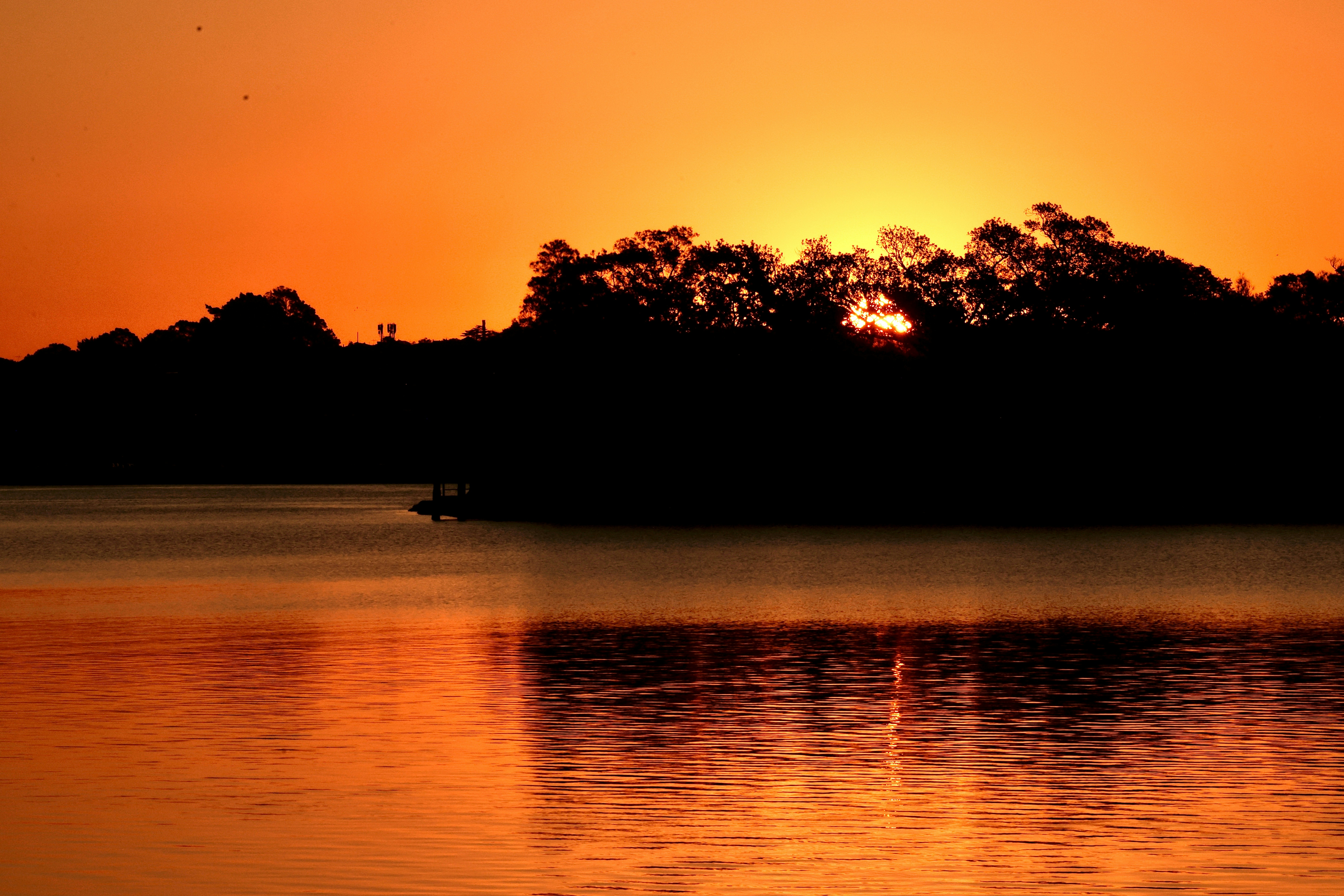 Golden sunset over water reflecting the sky.