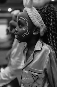 A girl is wearing face paint and pajamas.