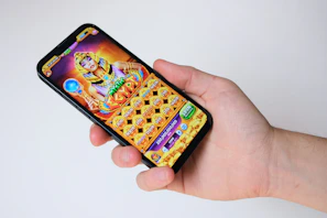 A hand holds a phone with an egyptian-themed game.