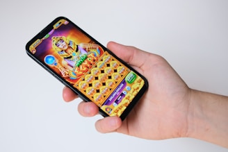 A hand holds a phone with an egyptian-themed game.