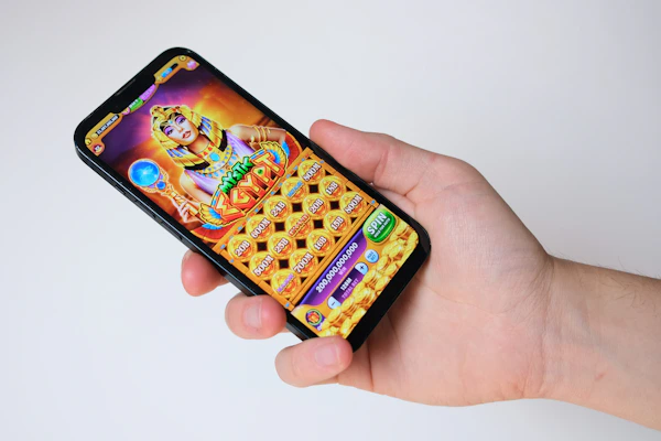 A hand holds a phone with an egyptian-themed game.