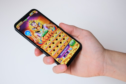 A hand holds a phone with an egyptian-themed game.