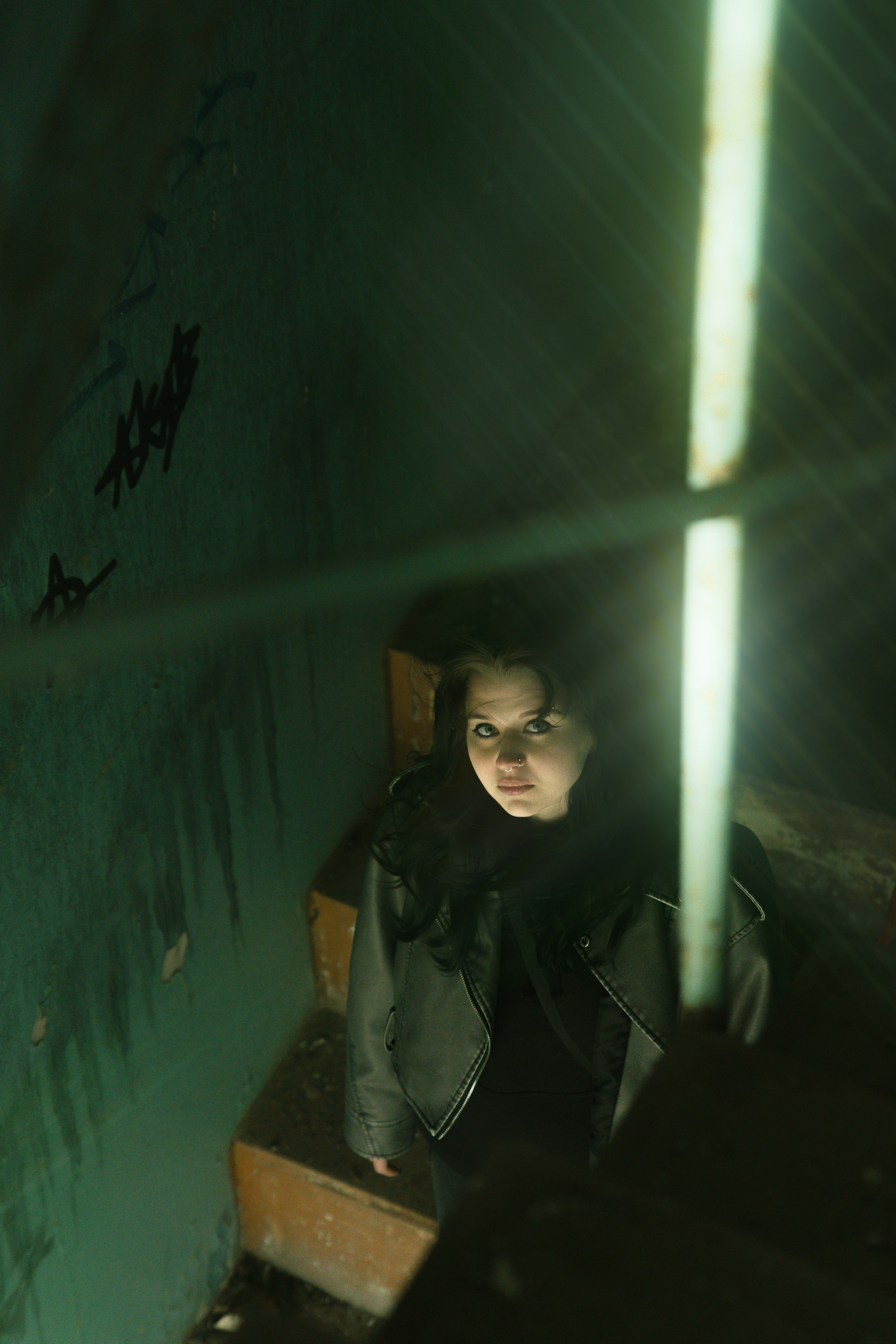 A woman looks up from a dark stairwell.