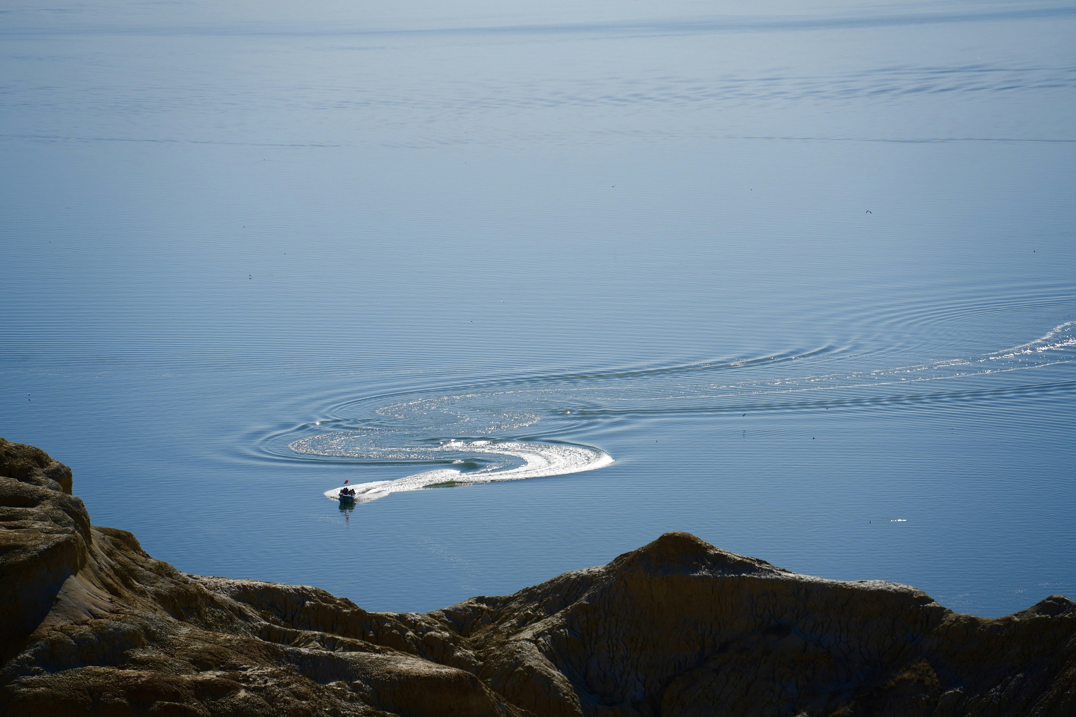 A boat travels across the blue water.