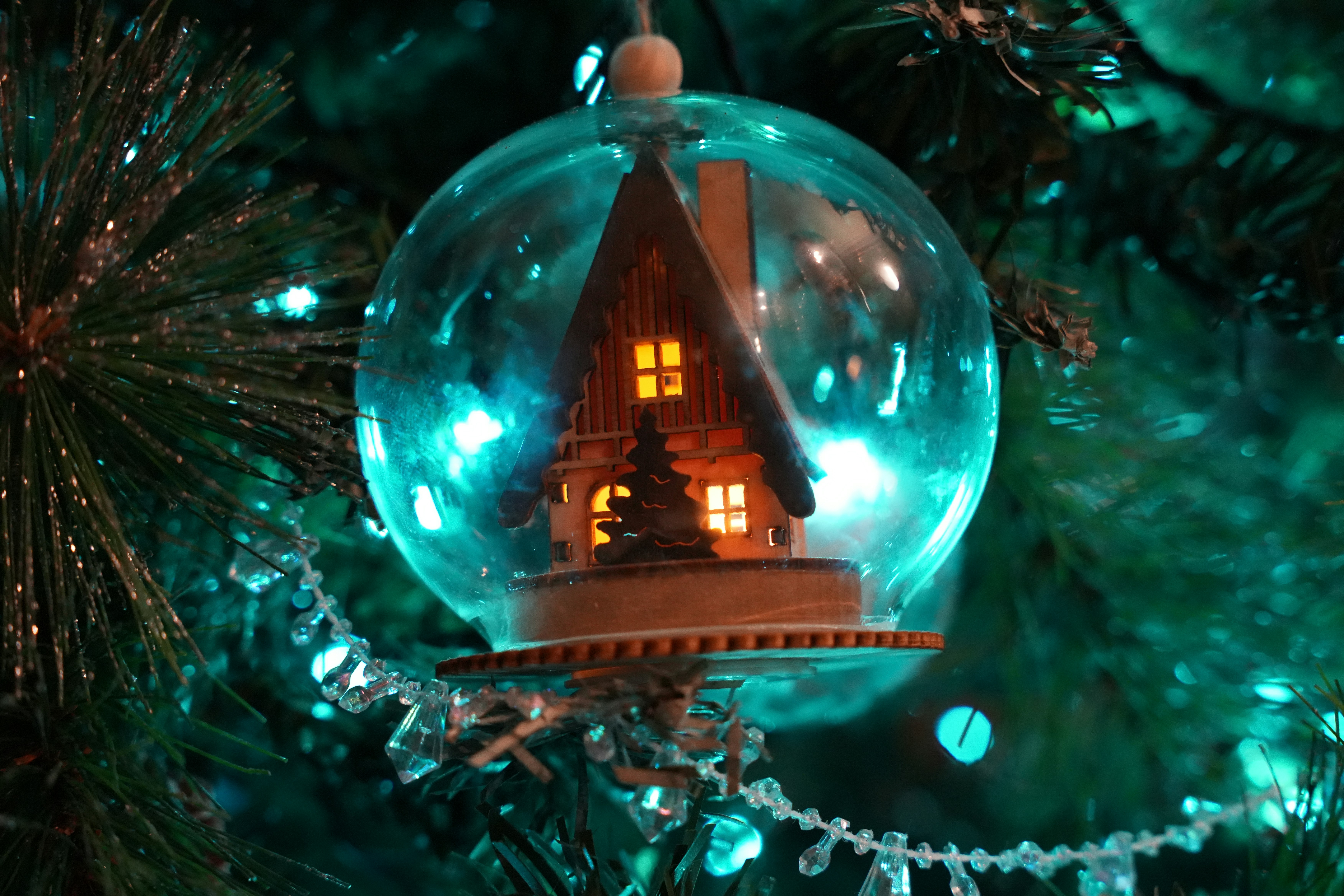 A christmas ornament with a house inside.
