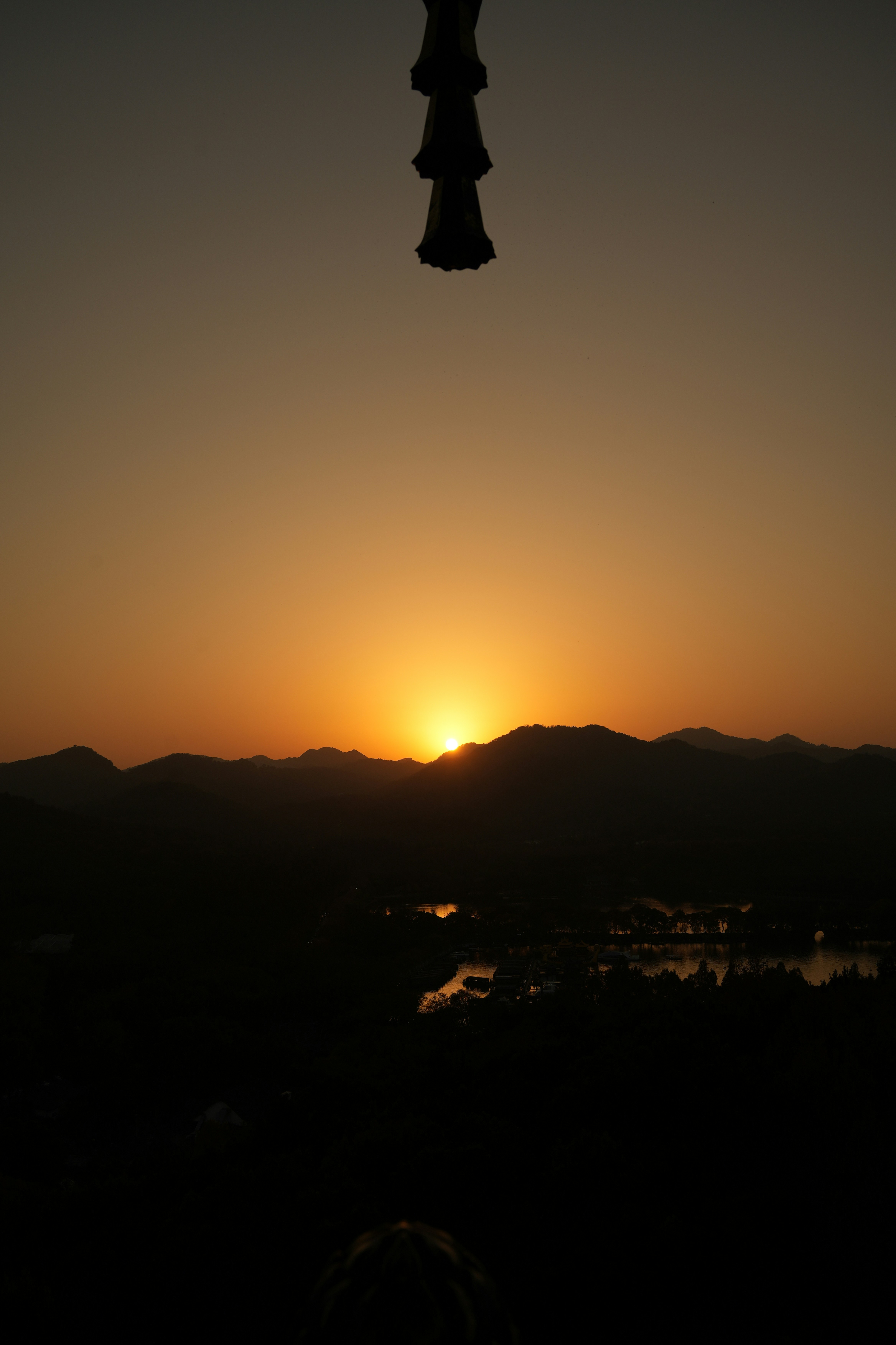 Sunset over mountains with a silhouette foreground.
