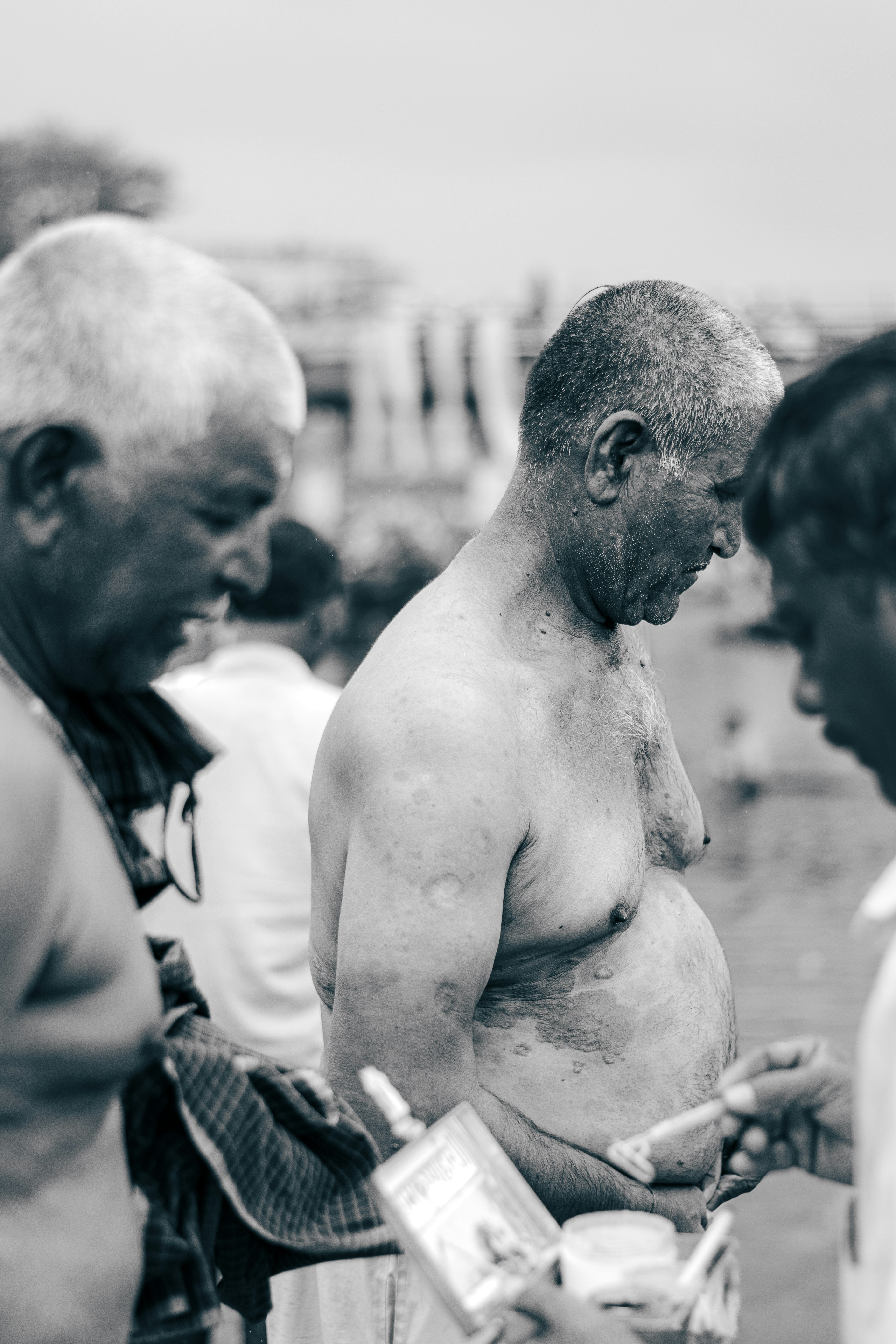 Men are gathered, looking down, in a candid moment.