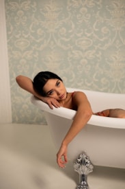 A woman relaxes in a luxurious, white bathtub.